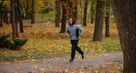 Fototapeta premium Man jogging in the autumn park