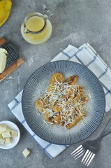 Pisang Keju Susu or Banana Cheese Fritters, typically Indonesian popular snack made from fried banana, topping with gated cheddar cheese and milk cream. Grey grainy background. 
