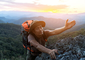Male climber with backpack reach out for help.