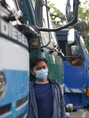 an Indonesian young man using a medical mask during the Covid-19 pandemic. Handsome Indonesian guy wears a surgical mask to protect himself from coronavirus