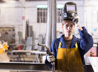 Portrait of female welder in factory workshop. High quality photo