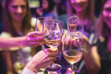 People celebrate and raise glasses, cheering with alcohol glasses with wine and champagne in the restaurant on corporate christmas birthday party event or wedding celebration