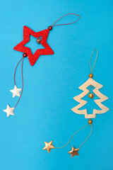 Simple Christmas tree decorations on a blue background. Minimalistic New Year card. Free space for text.