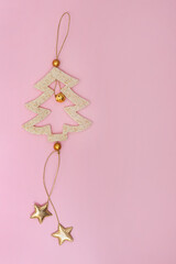 Pink background and simple Christmas tree decoration. New Year card in a minimalistic style.