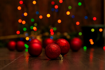 Warm Christmas background in red-brown tones. Christmas balls on a background of lights. Strong blur.