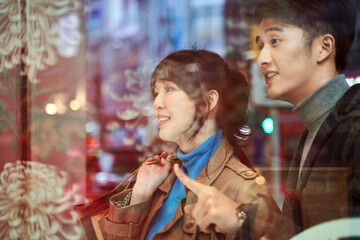 Obraz premium young asian couple standing in front of shop window