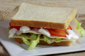 sandwich au jambon et crudités sur une assiette