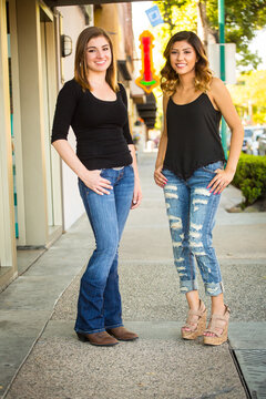 Hispanic and Caucasian young women standing together in an urban setting