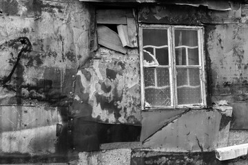 Broken window on wall of abandoned house