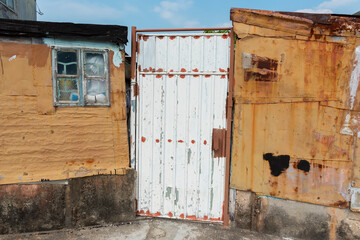 Broken window and door on wall of abandoned house
