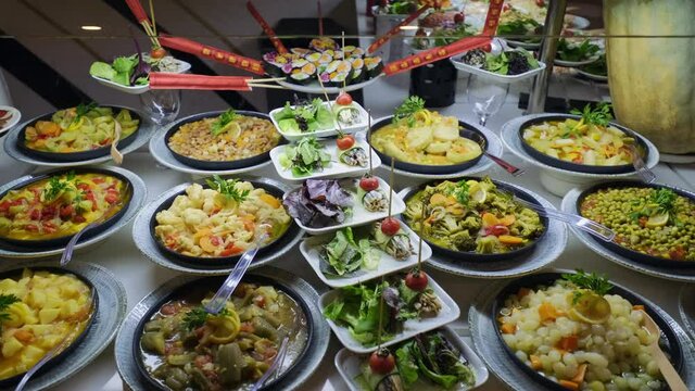 There are olive oil dishes and vegetables at the open buffet. 4k. slow motion.