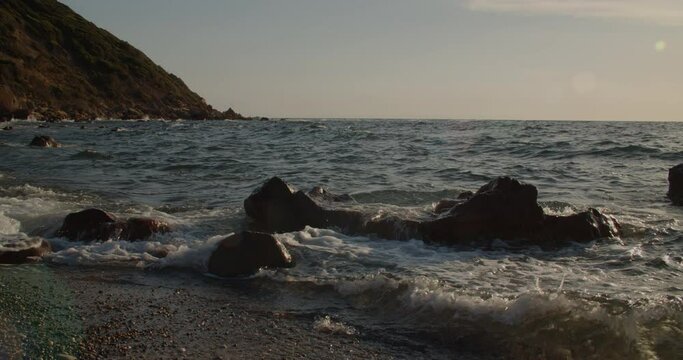 Waves crashing against rocks in paradise beach in Sardinia, static, slow motion