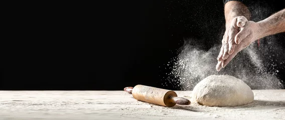 Foto auf Glas White flour flying into air as pastry chef in white suit slams ball dough on white powder covered table. concept of nature, Italy, food, diet and bio © Надія Коваль