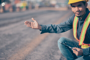 Asian man Engineer worker use tablet checking work on site road construction