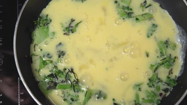 cooking fried eggs in a pan with broccoli. Omelette for Breakfast. healthy food