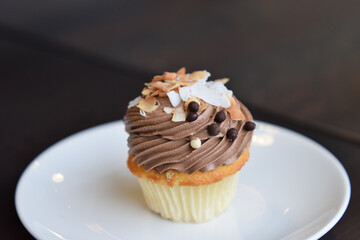 Chocolate cupcake with chocolate chips and sliced almond on top isolated