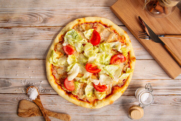 Chicken caesar pizza with tomatoes and lettuce