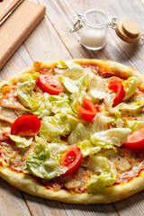 Chicken caesar pizza with tomatoes and lettuce