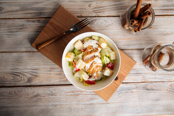 Caesar salad with chicken on the wooden board