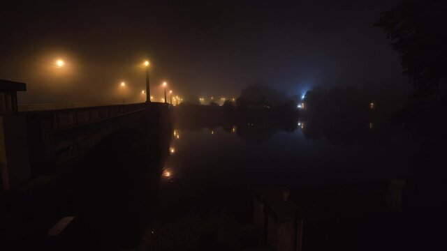 Manes bridge over Vltava river with street lamps at night in mist,Prague,Czechia.