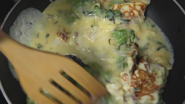 Fried eggs with broccoli in a iron frying pan. Food preparation