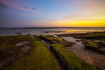 Seascape. Beach with rocks and stones. Low tide. Sunset time. Slow shutter speed. Soft focus. Melasti beach, Bali, Indonesia