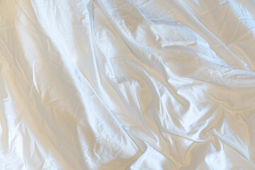 Unmade bedroom in the morning. White blanket with wrinkle messy on bed. Copy space, top view