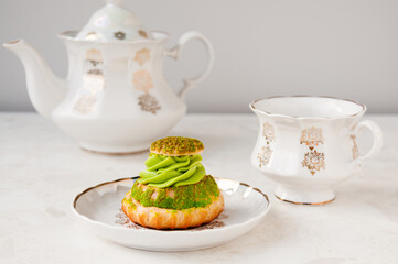 Pistachio cream cake and white tea set on the table