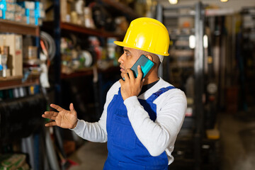 Head of construction store talking on mobile phone in a warehouse