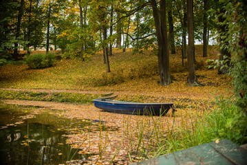 little wooden boat on the lake in the autumn park