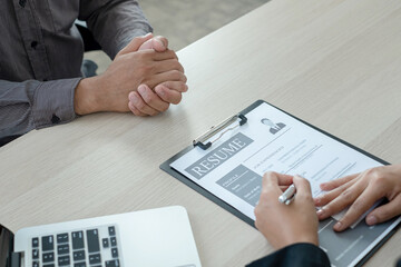 Business people hold a resume and talk to job applicants for job interviews about careers and Her...
