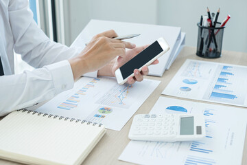 The businessman hand sits at their desks and calculates financial graphs showing the results of their investments planning the process of successful business growth