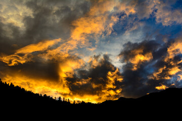 Sun reflected clouds in the sky and silhouette of mountains of Himalaya