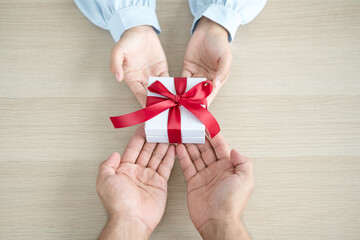 A hand holding a gift box Glad to be the giver of surprise with excitement, joy on the holidays, Christmas, birthdays, or Valentine's Day concept