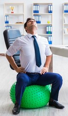 Young businessman doing sports stretching at workplace