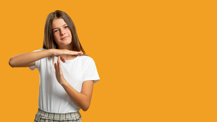 Break time. Child strike. Stop gesture. Portrait of relaxed skeptic girl in white showing T hand...