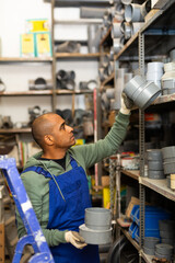 Confident latin american handyman man choosing materials for overhauls in building materials store