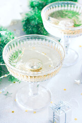Festive christmas table with glasses of champagne and confetti, holiday card, selective focus