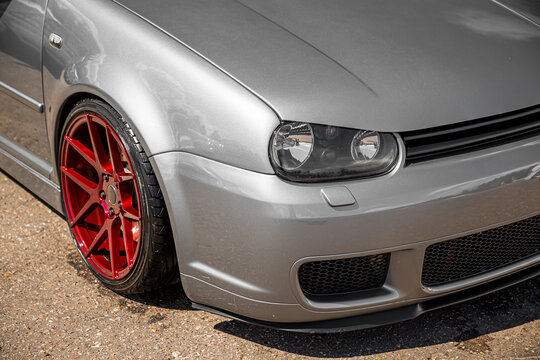 Moscow, Russia - July 19, 2019: Tuned low sport hatchback with red Candy colored alloy wheels. Golf mk 4 is on the street. Stanced lowrider with badboy hood