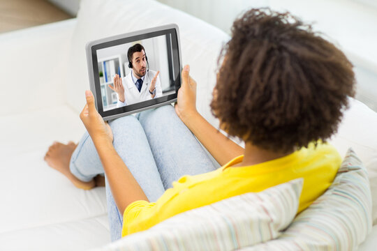 medicine, healthcare and technology concept - african american woman having video call or online consultation with doctor on tablet pc computer at home