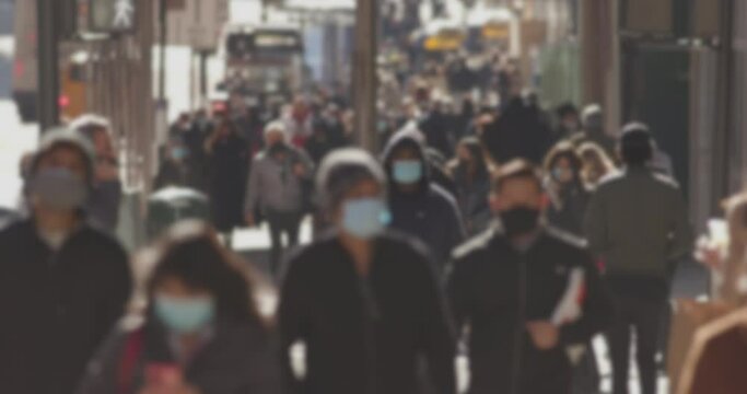 Crowd of people wearing masks walking street in New York City during covid 19 pandemic in November 2020