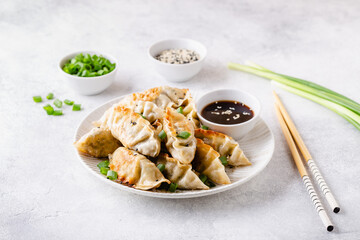 Fried dumplings gyoza with soy sauce, and chopsticks.
