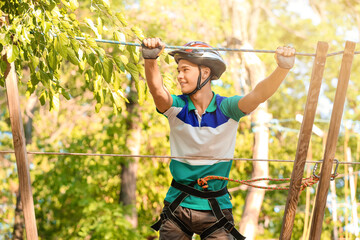 Teenage boy climbing in adventure park