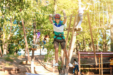 Teenage boy climbing in adventure park