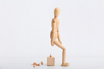 Wooden mannequin and pins on white background. Concept of hemorrhoids