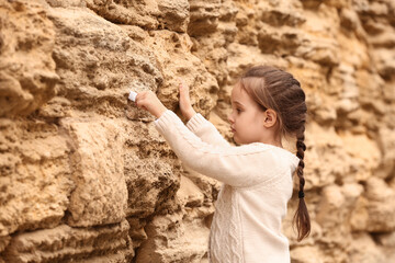 Little girl placing note in the Wailing Wall