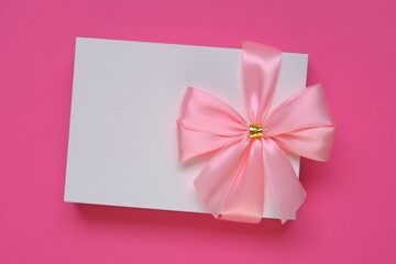 Postcard blank. Holiday greeting card with pink bow on bright pink background.Birthday  blank postcard.Women's Day, Mother's Day, Valentine's Day.
