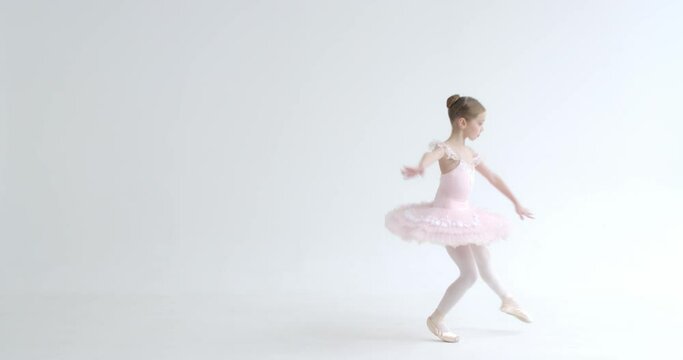 Elegant little girl in a white tutu, dance ballet and perform choreographic elements on a white background, rehearsal.