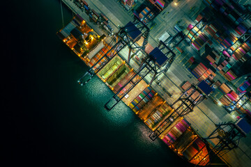 Container ship loading and unloading in deep sea port, Aerial view at night