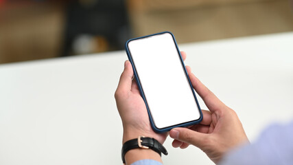 Close up view of businessman hand holding mobile phone with white screen for input the text.